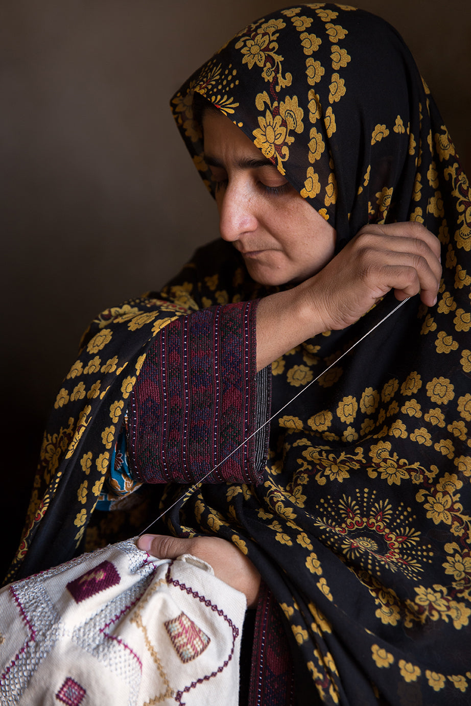 A Baluchi woman embroidering a cushion