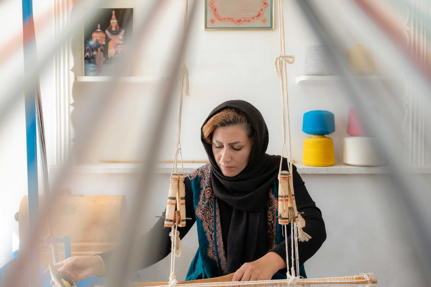 woman weaving textile with a handloom