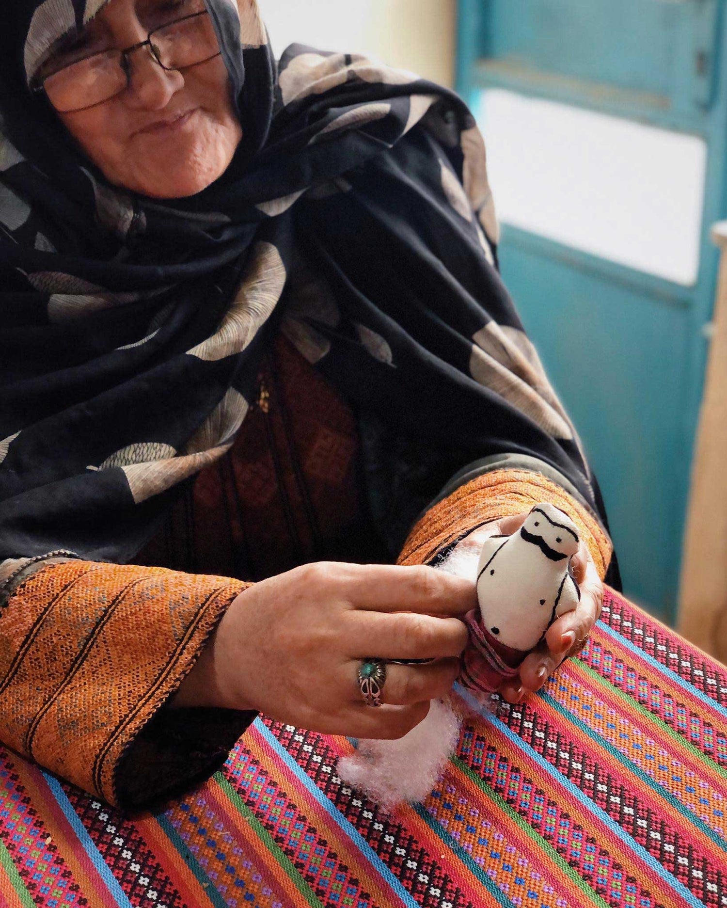 Baluchi woman working on  a Naser charm 