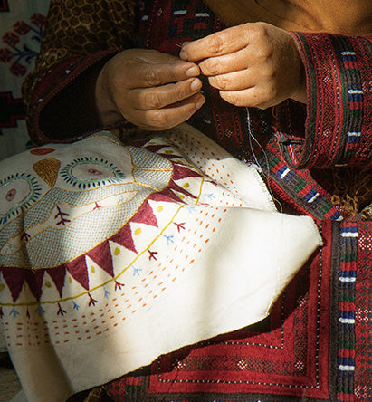 woman embroidering Sun Lady cushion