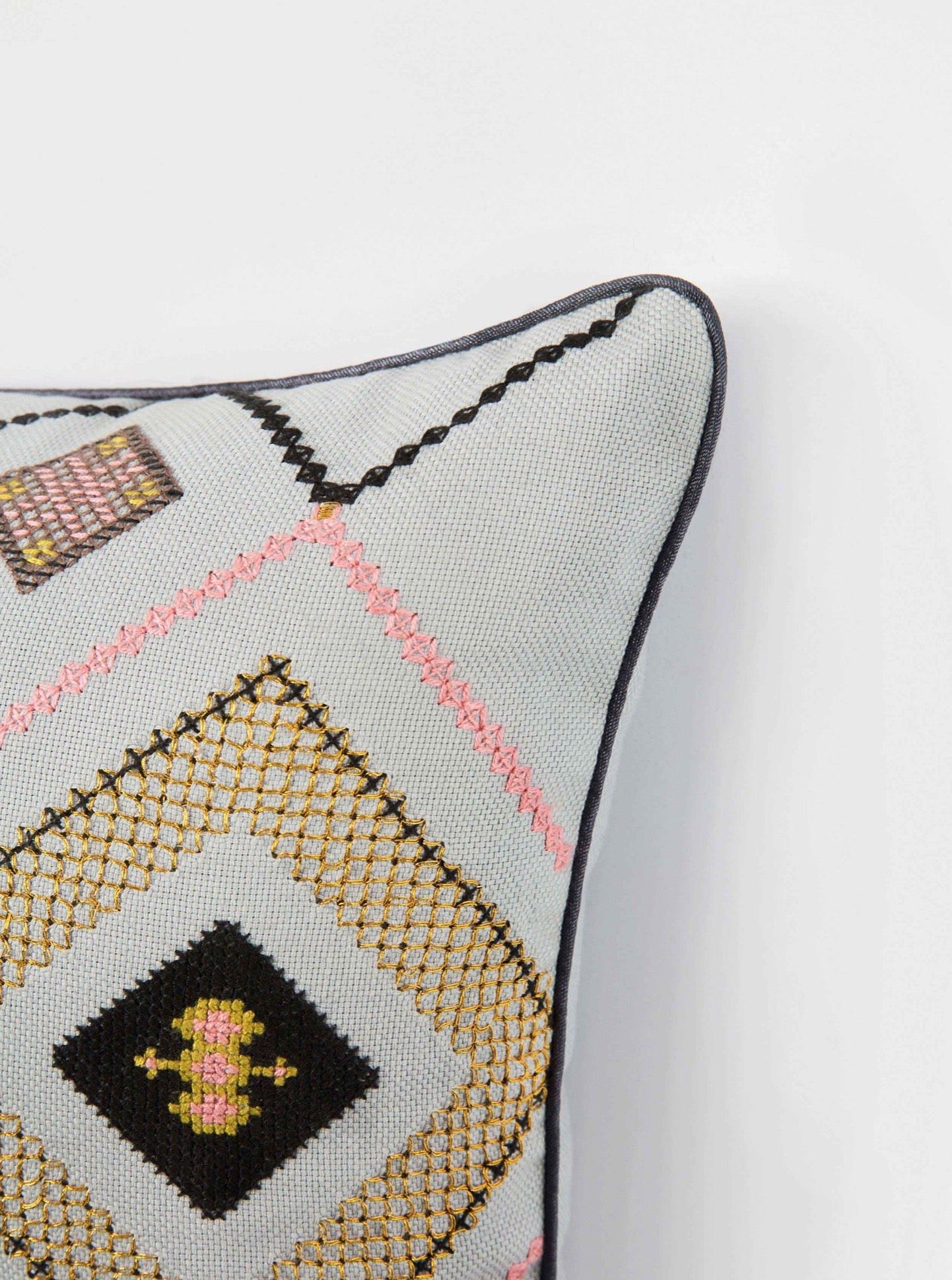 Detail close up of Silver gray/ Gold Gouder cushion with embroidery