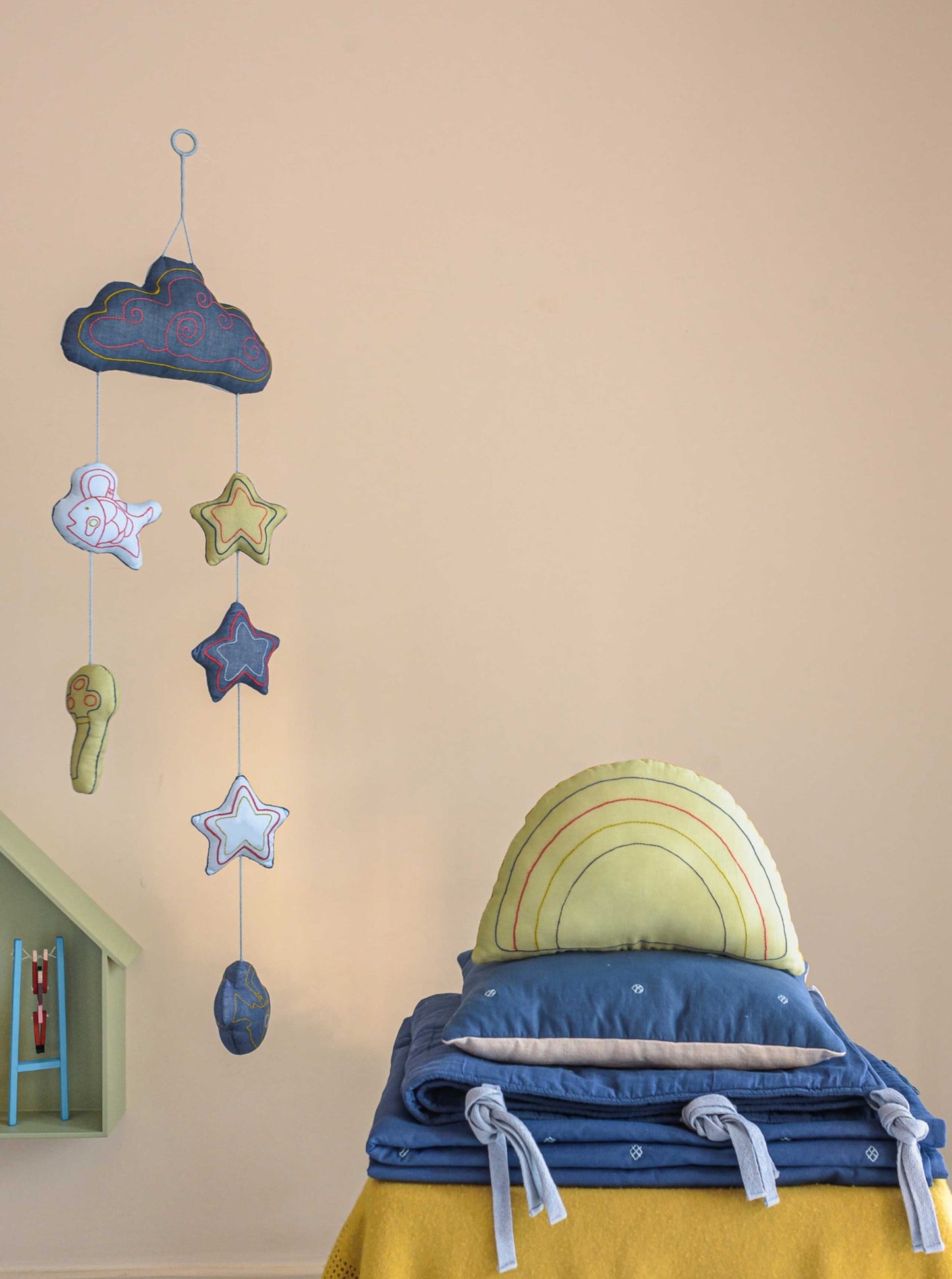 Apple Green Rainbow decorative kids cushion with embroidery on top of Blue Bandook baby pillow, bumper and blanket and Moshkel Gosha baby mobile