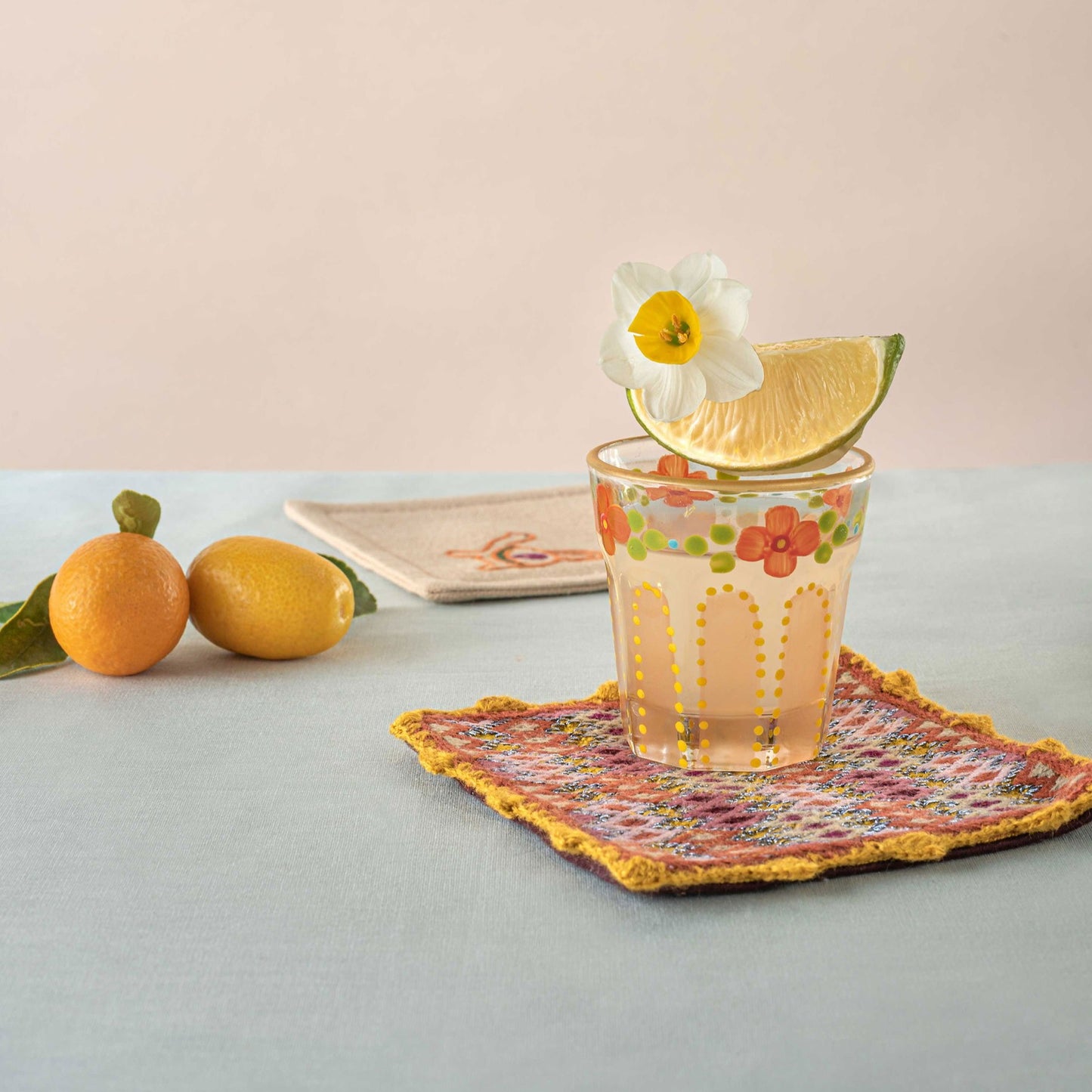 Coral saghi shot glass placed on top of Bibi coaster set on a table