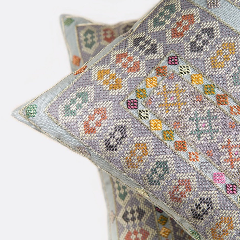 Corner detail photo of Midnight blue Zee square cushions with intense Baluchi embroidery on top of each other