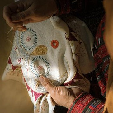 A Baluchi woman embroidering Sun Lady cushion