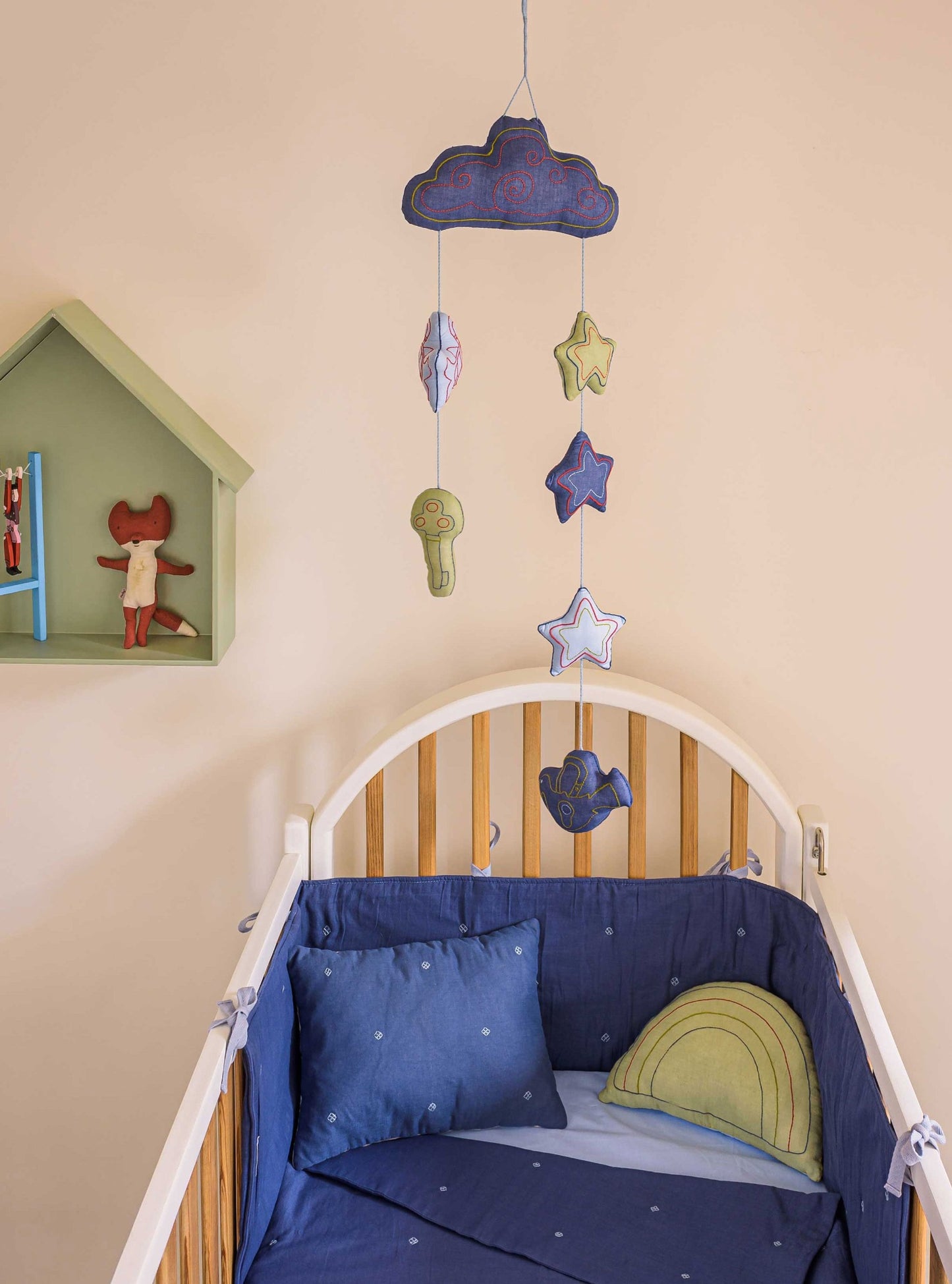 Blue bandook pillow, blanket, bumper, Moshkel Gosha baby mobile with Lime rainbow cushion all set up in a baby nursery room