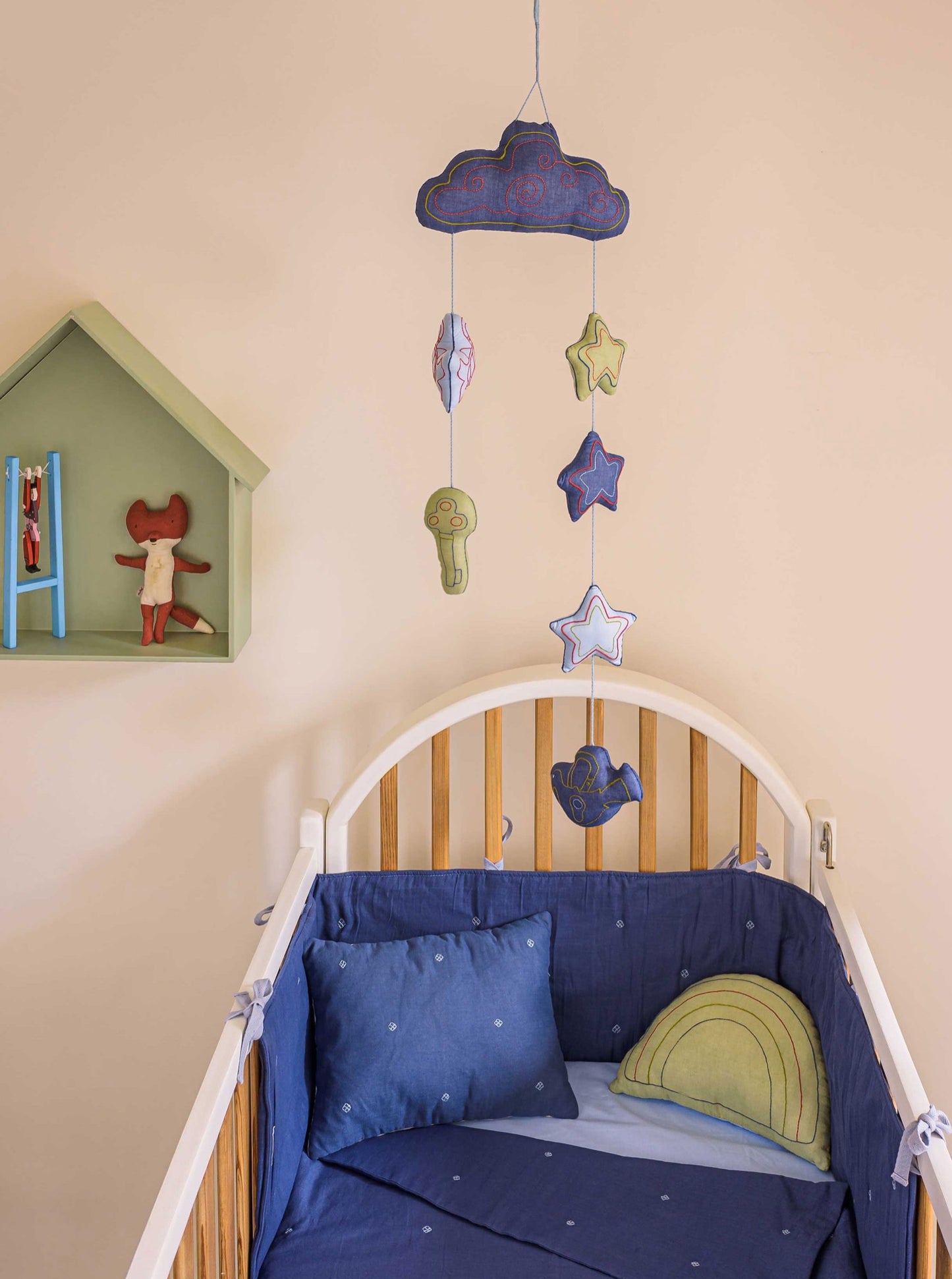 Blue Lucky Charm baby mobile hanging from ceiling placed in a nursery room 