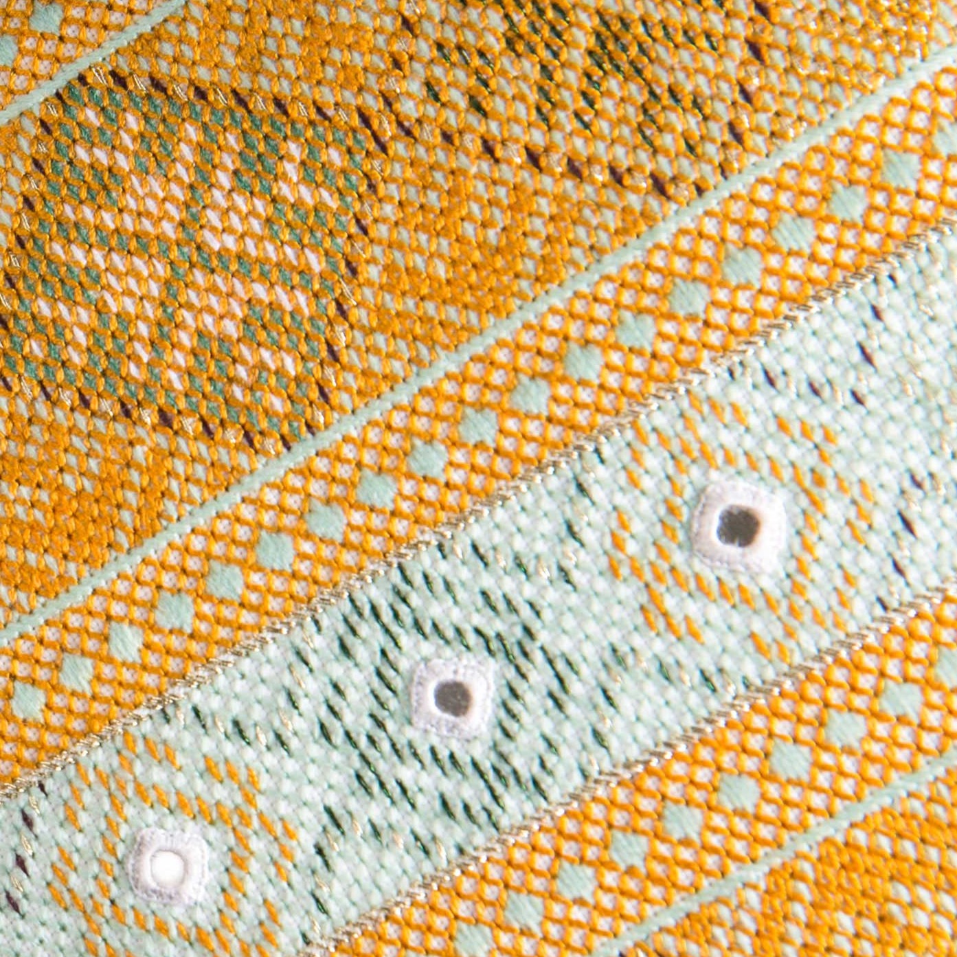 Close up detail of Sage/ Orange Noor editioned cushion with intense Baluchi embroidery