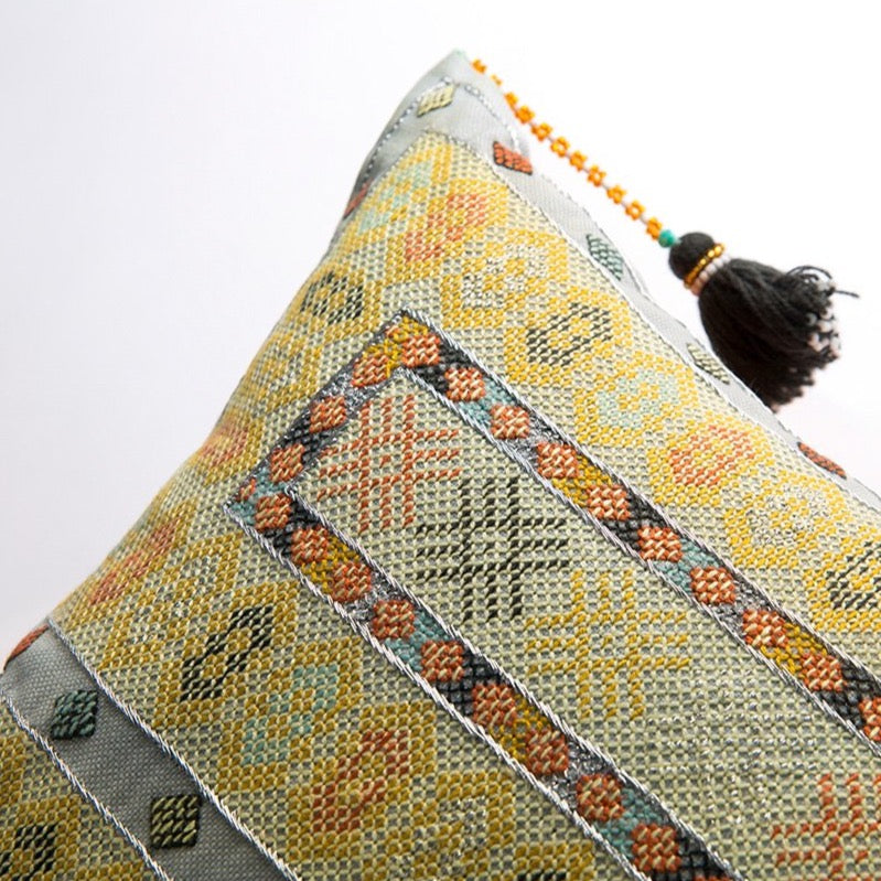 Close up diagonal photo of Sunlight yellow Zee square cushion with intense Baluchi embroidery and corner tassel